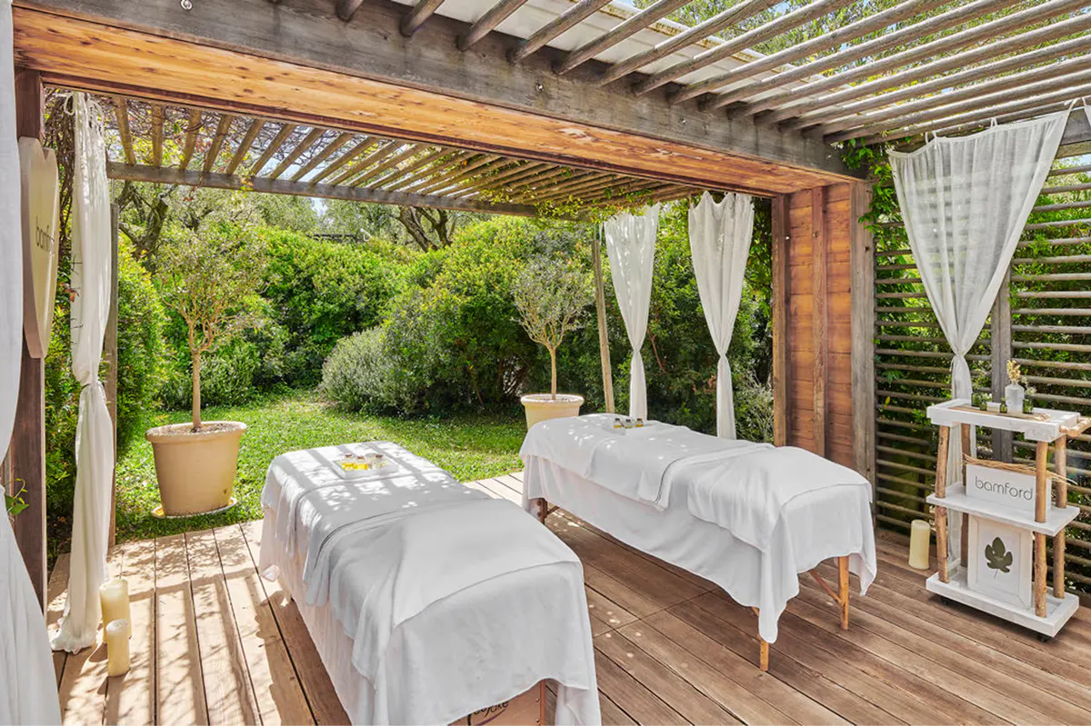 Spa treatment room with therapist and client on massage bed