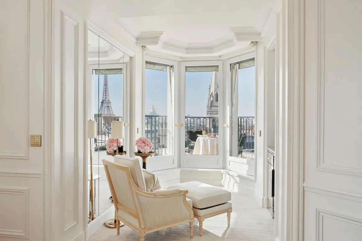 A bay window seating nook with cream upholstery facing the Eiffel Tower