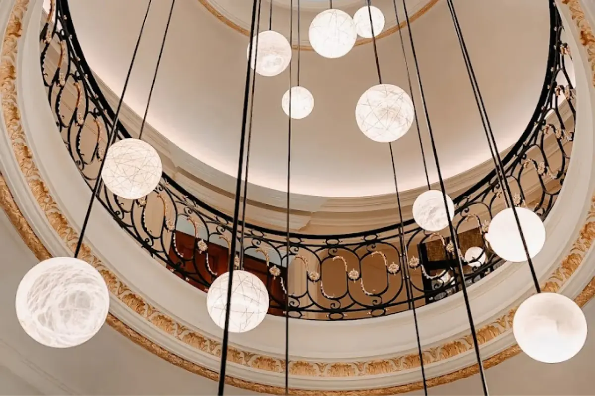 A central foyer with arched ceiling, pendant lights suspended above wooden and stone finishes