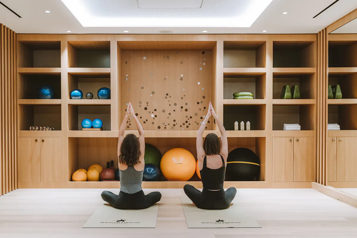Meditation room with floor cushions, natural wood shelving, and soft natural light