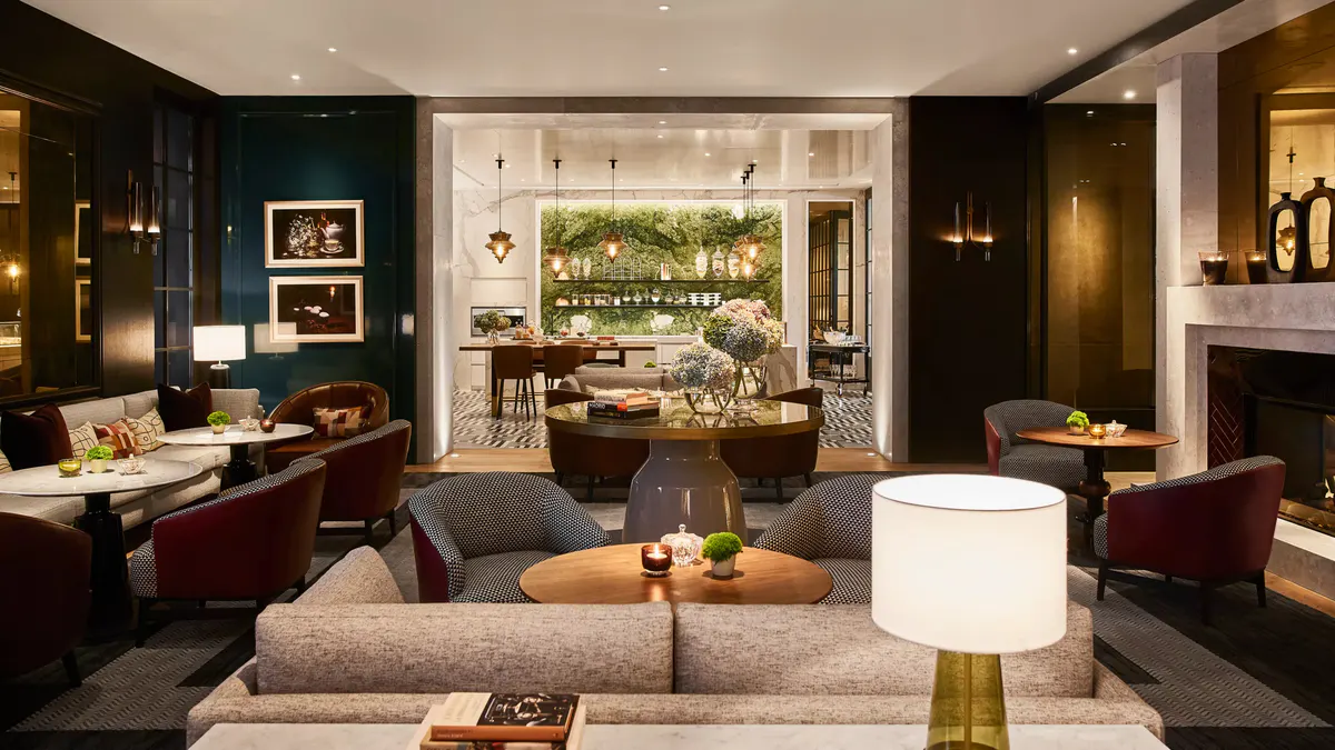 A lounge area with dark walls, fireplace, multiple seating zones, and warm wood paneling
