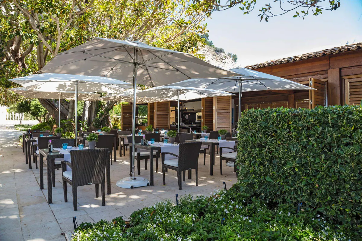 Black chairs under market umbrellas on a modern stone patio