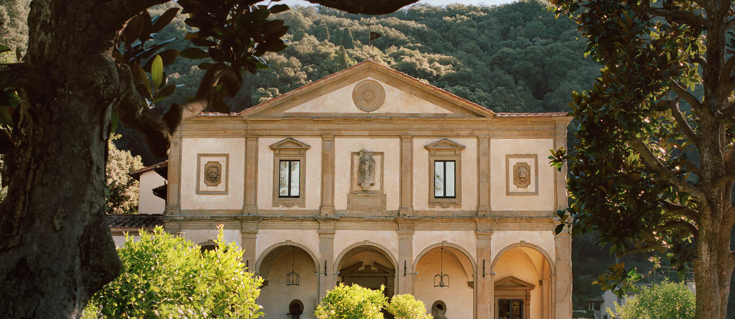 The Renaissance facade of Villa San Michele framed by magnolia trees, its arcade open to the gardens