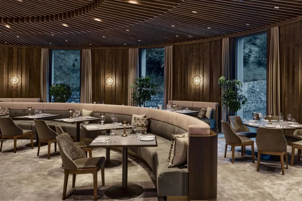 Fine dining room with wood elements, cream furnishings, soft lighting, and mountain views