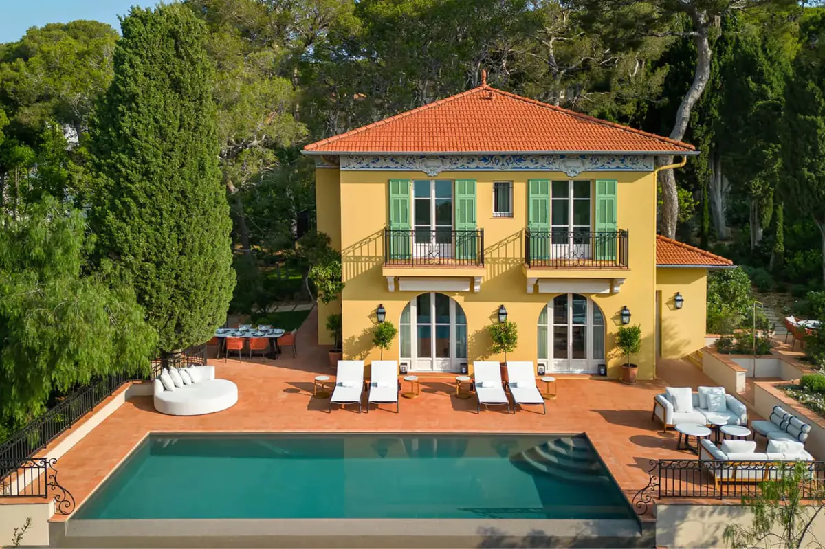 Golden villa with turquoise pool and garden lounge chairs