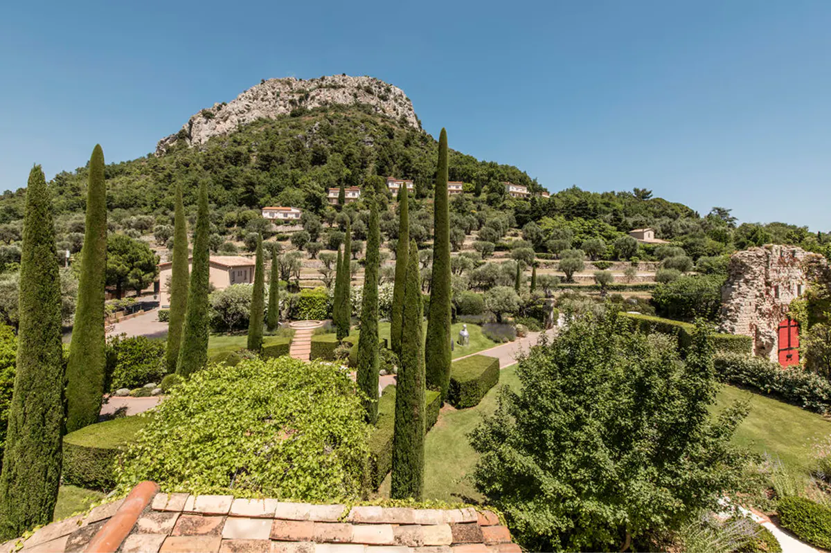 Hilltop terrain with cypress trees and rock formations overlooking valley