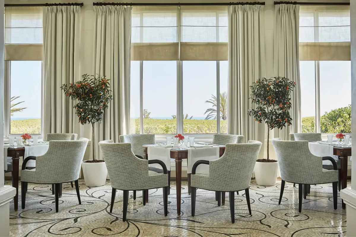 Bright dining area with floor-to-ceiling windows and contemporary furnishings