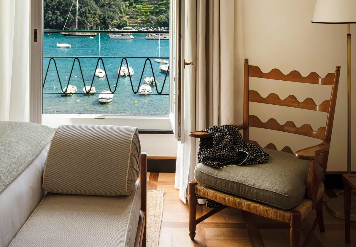 Suite interior with mirror, seating area, and harbor-view balcony