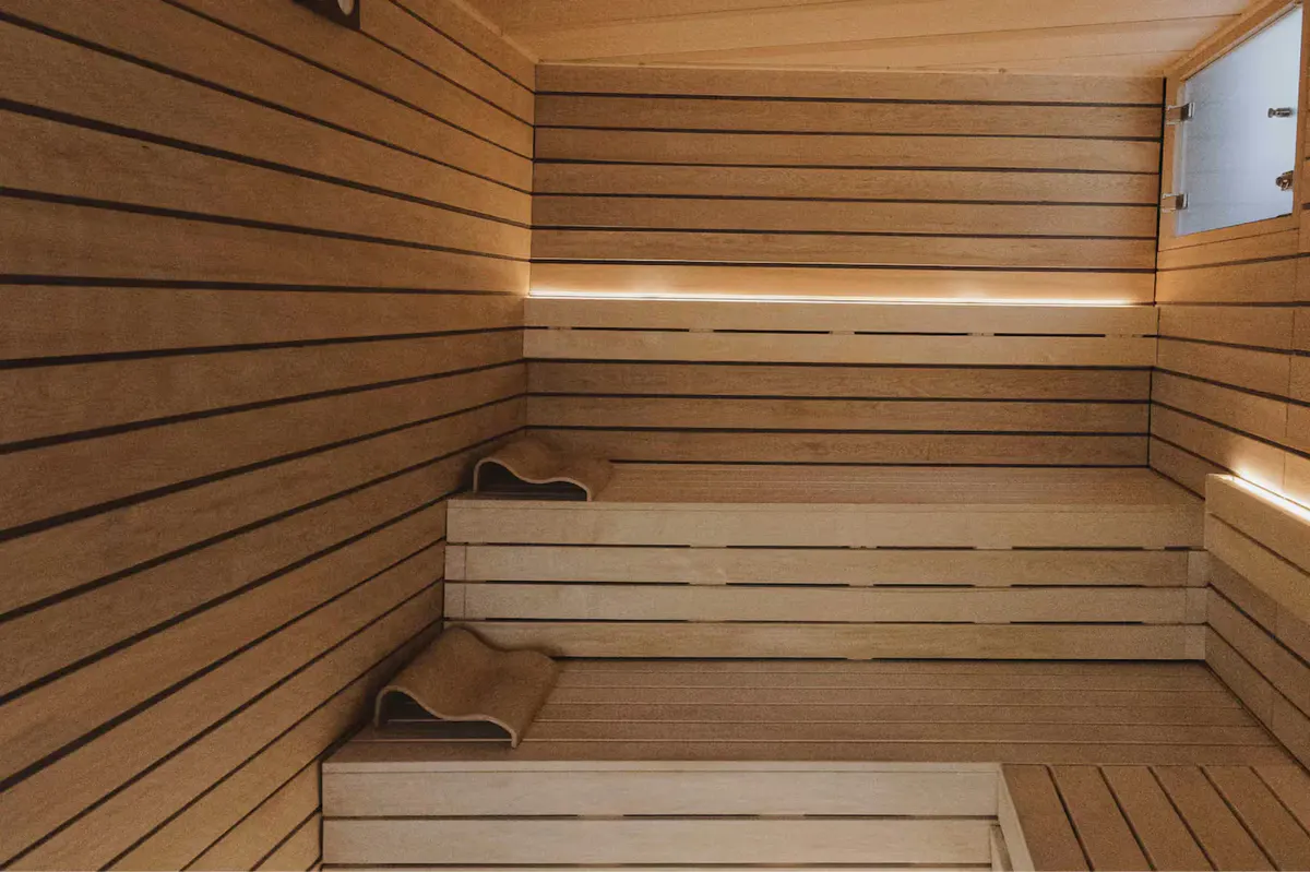 A fitness center with dark wood floors, equipment, and glass doors