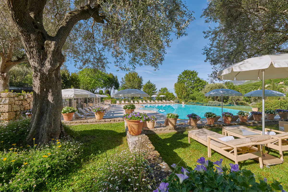 Garden cabana with pergola shade and lounge seating under cypress trees
