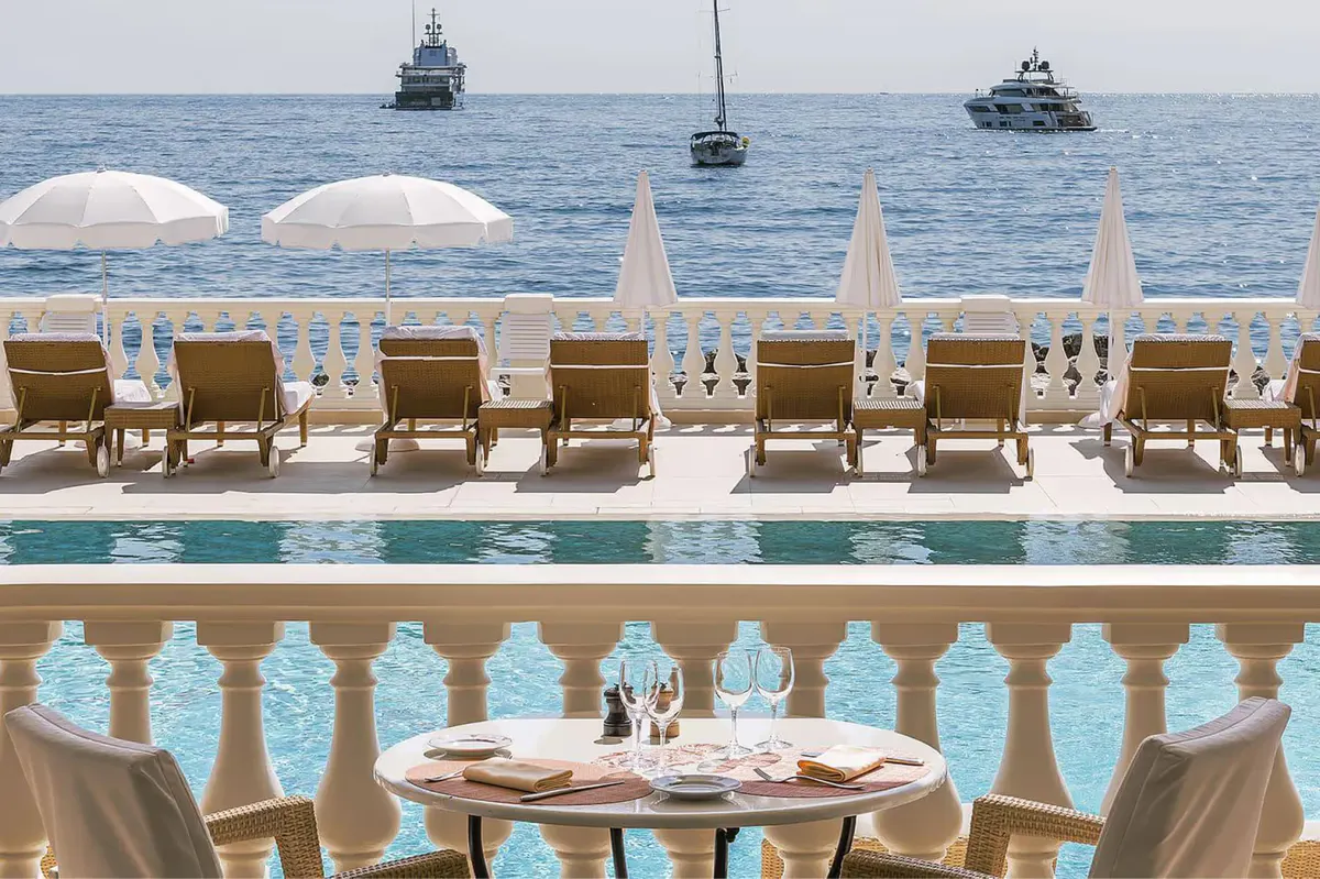 Upper terrace with sea views, umbrella canopies, and dining table