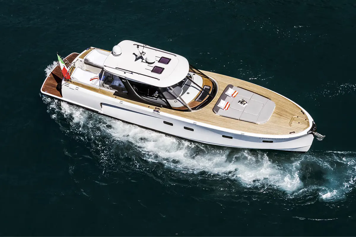 Luxury yacht cabin interior with dashboard, seating, and doors opening to sea view