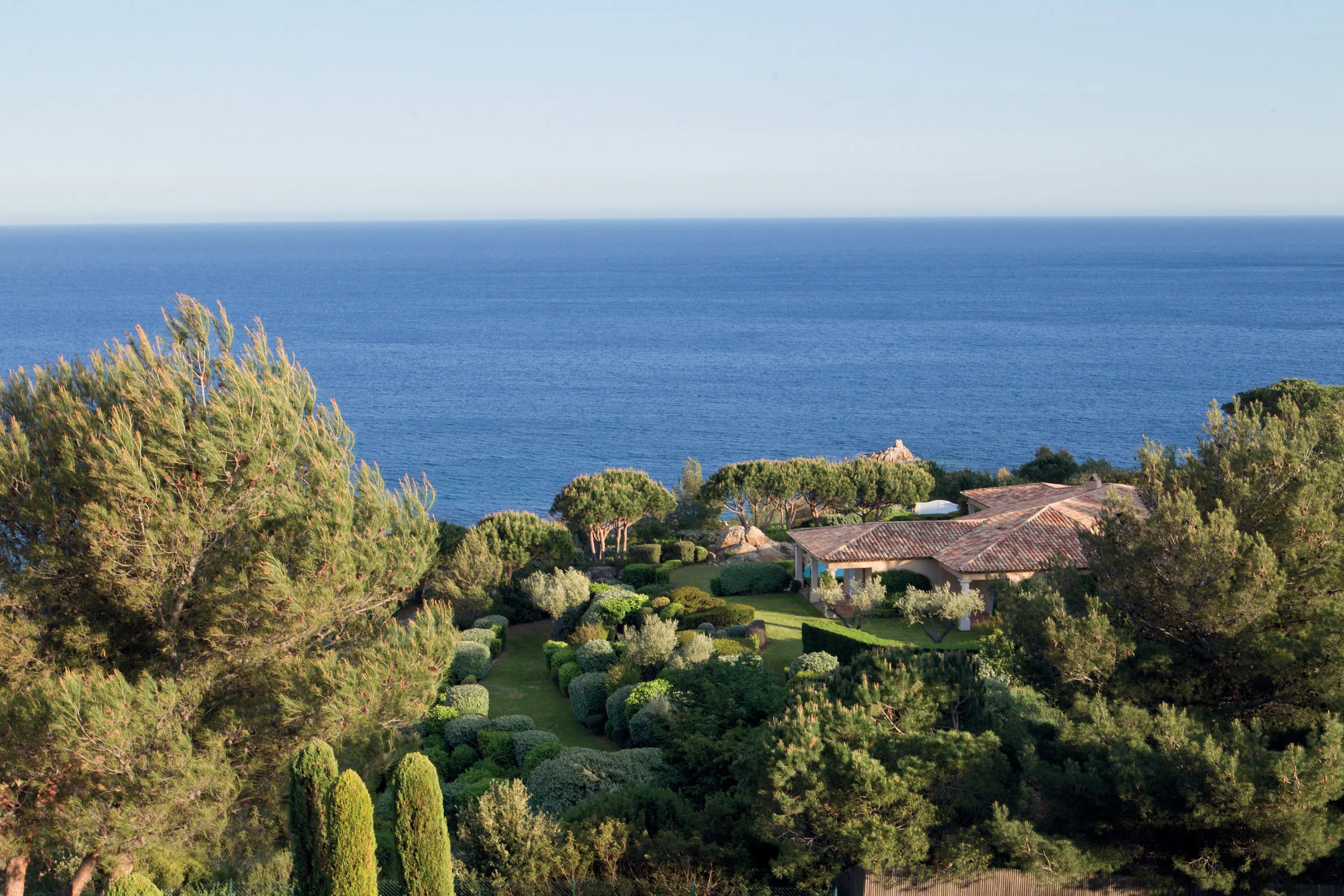 Aerial view of property set in hillside overlooking the sea
