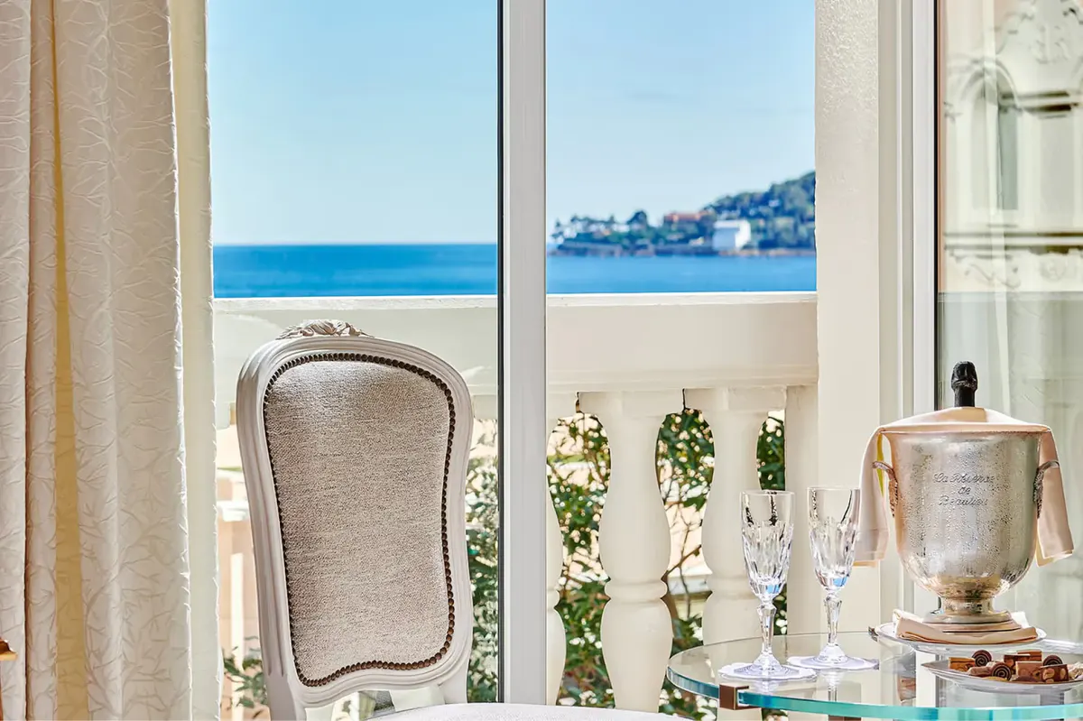 Window with mirror and potted plant overlooking the sea and coastline