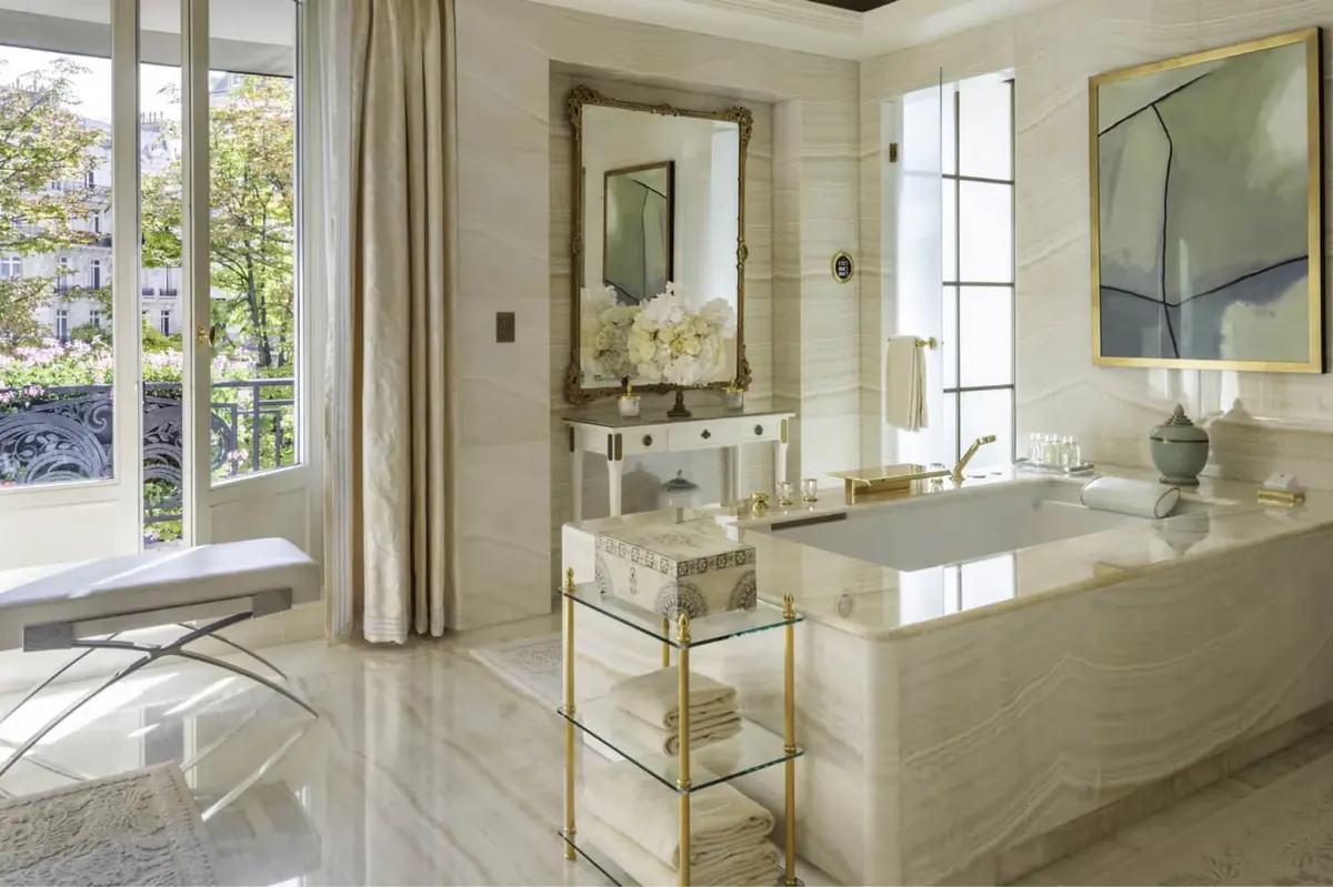 A detail shot of a marble bathroom vanity with a white flower arrangement