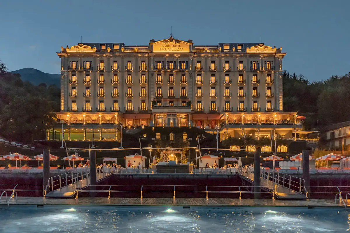Hotel facade glowing in golden light at dusk with lake foreground