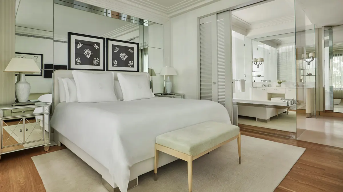 Contemporary bedroom with mirror-lined closet and pale wood furnishings