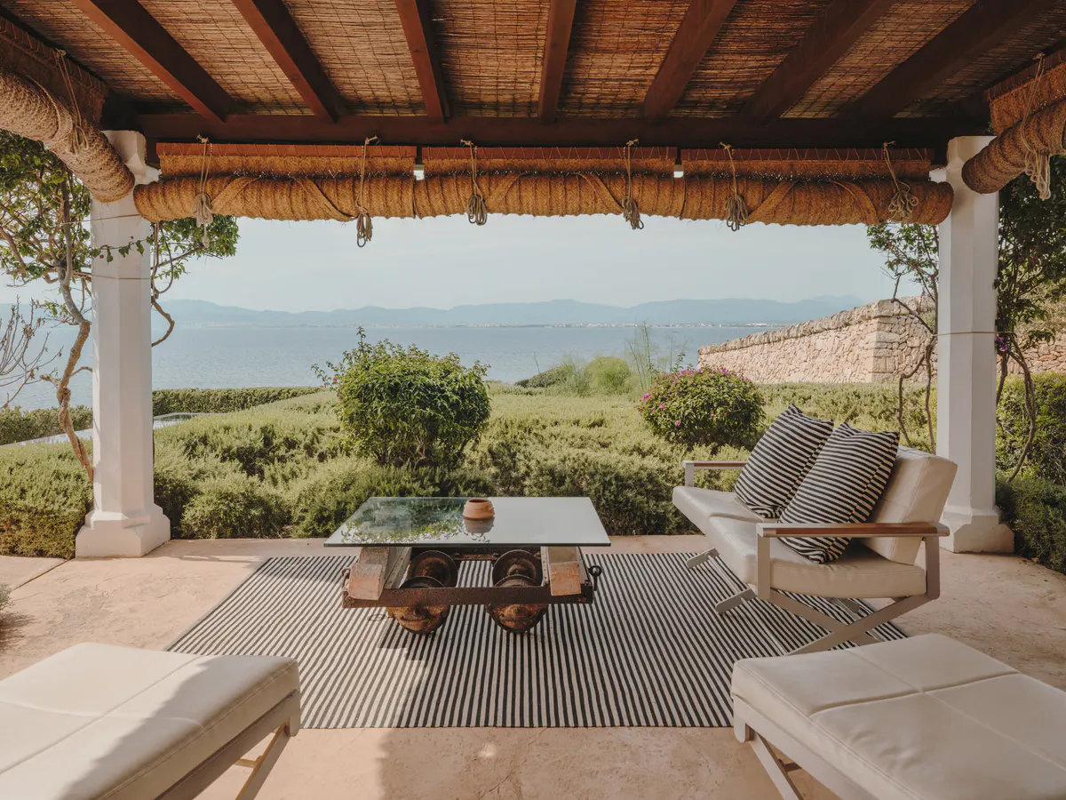 A terracotta villa facade set in golden-hour light, framed by cypress landscaping