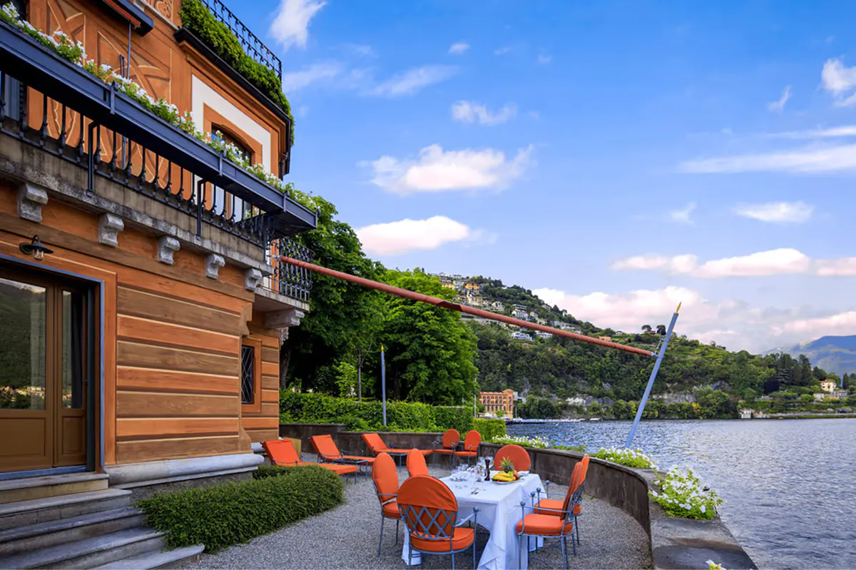 Terrace with coral lounge chairs on a wooden boathouse overlooking the lake at sunset