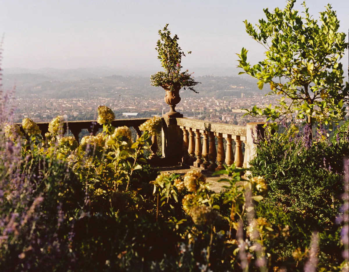 Stone balustrade with decorative urn, lavender plantings, and panoramic view of Florence spread below