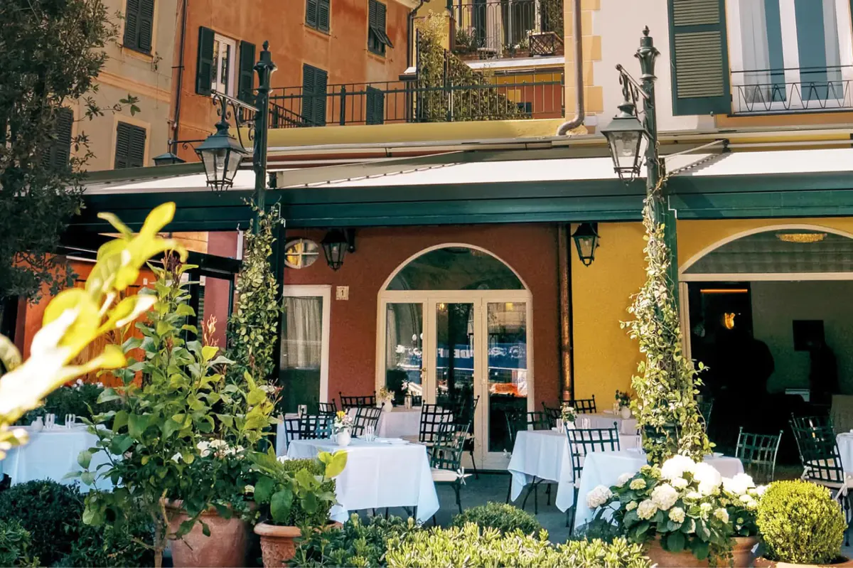 Colorful restaurant facade with white tables and ivy