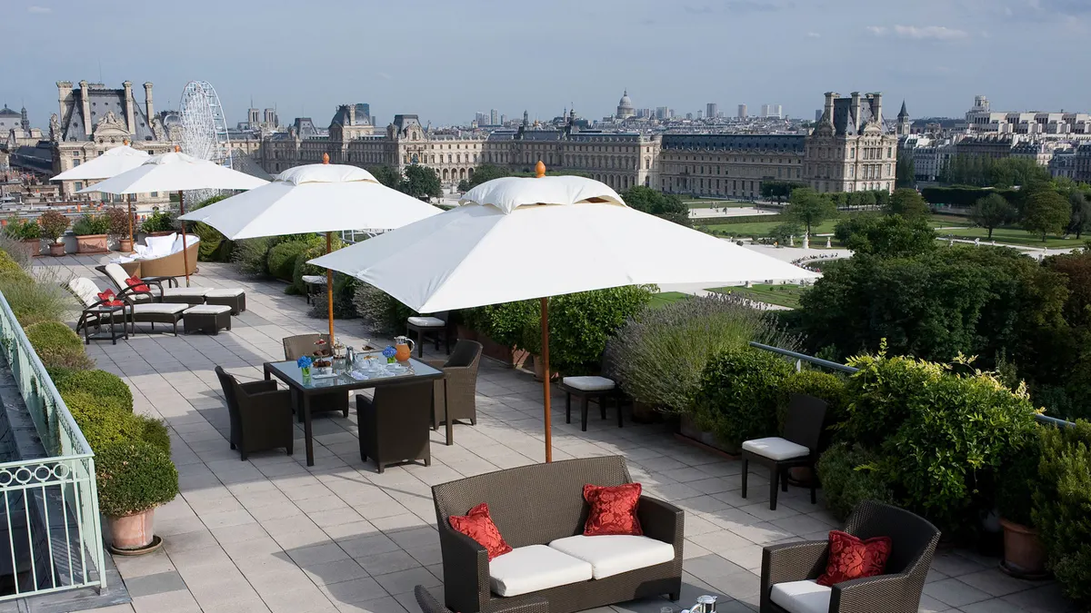 The terrace area with shade structures and seating with Paris skyline views across the city