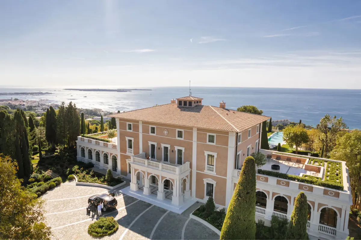 Cream-colored château with sea views, pool complex, and surrounding estate grounds