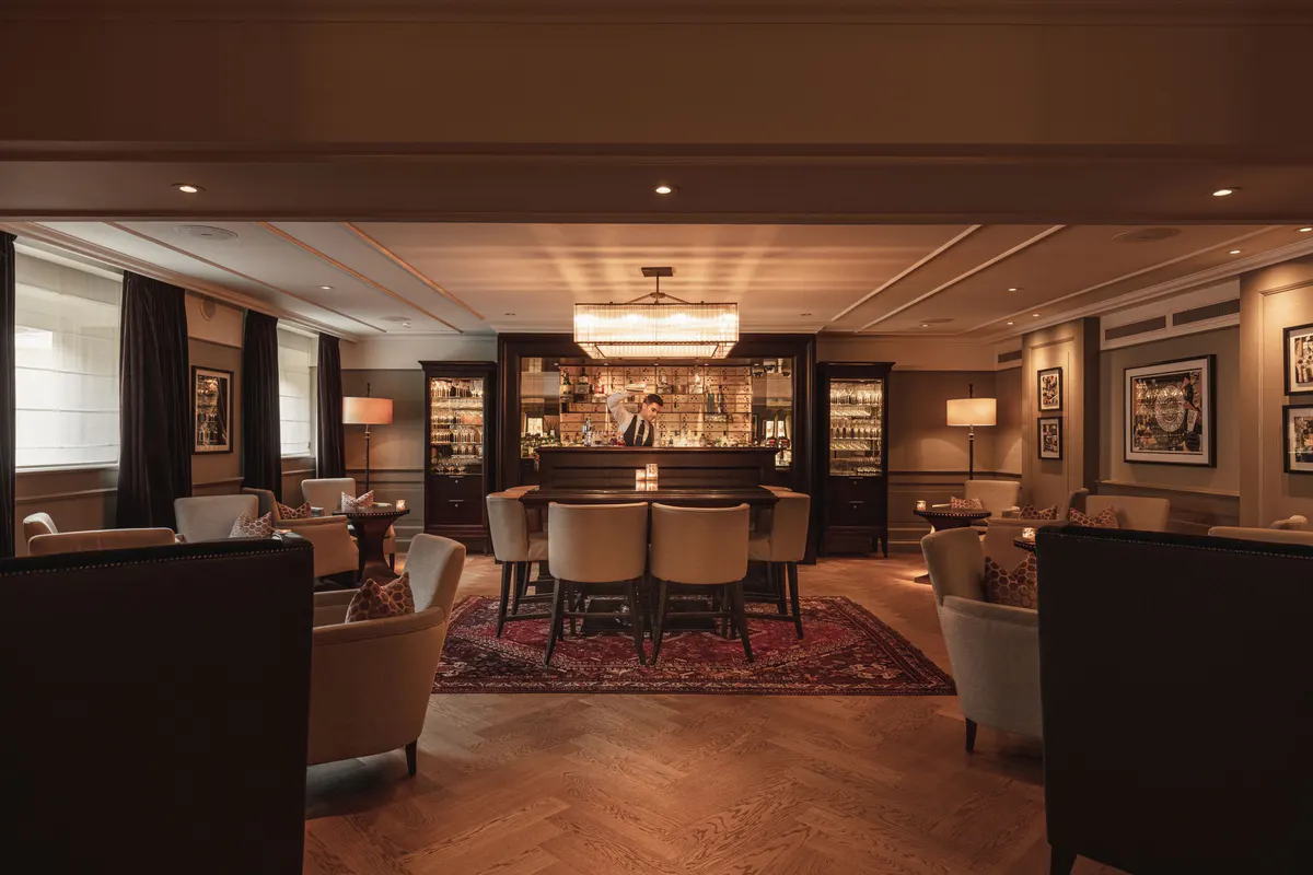 A lobby with dark wood finishes, illuminated display cabinets, and a warm-toned orientation counter