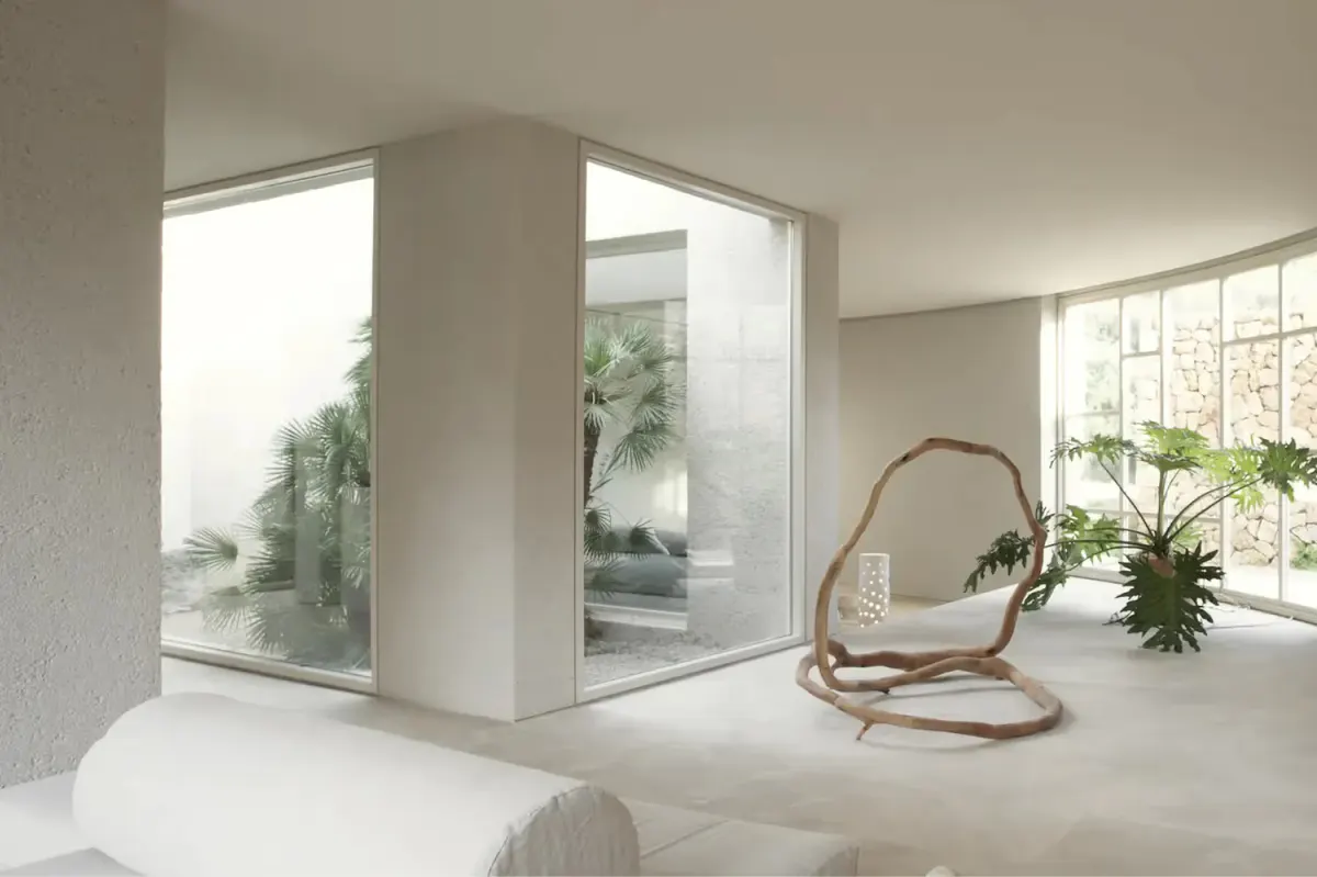 Meditation or yoga room with geometric window frame, rattan hanging chair, and potted plants