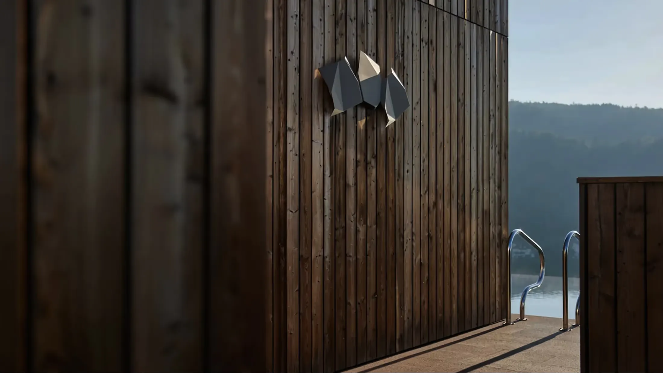 Wooden exterior wall and deck with mountains visible through the glass doors at dusk
