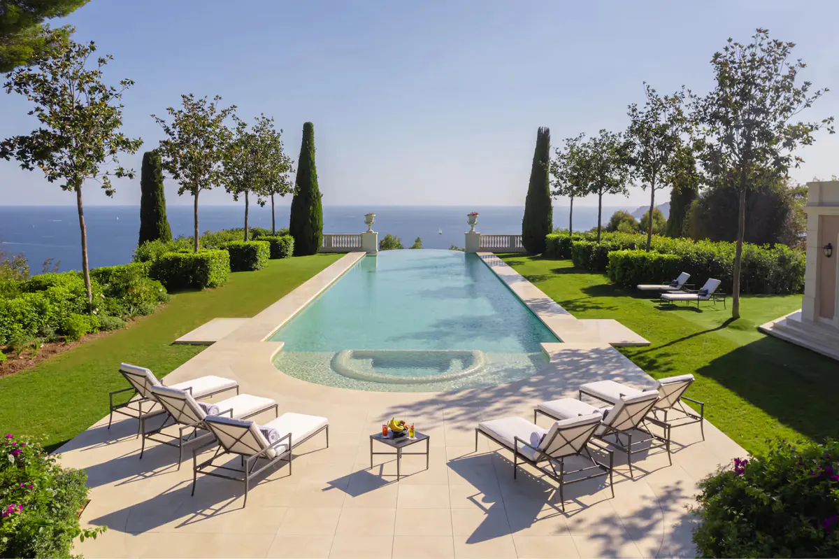 Stone balustrade terrace with sea views, cypress alleys, and manicured garden beds