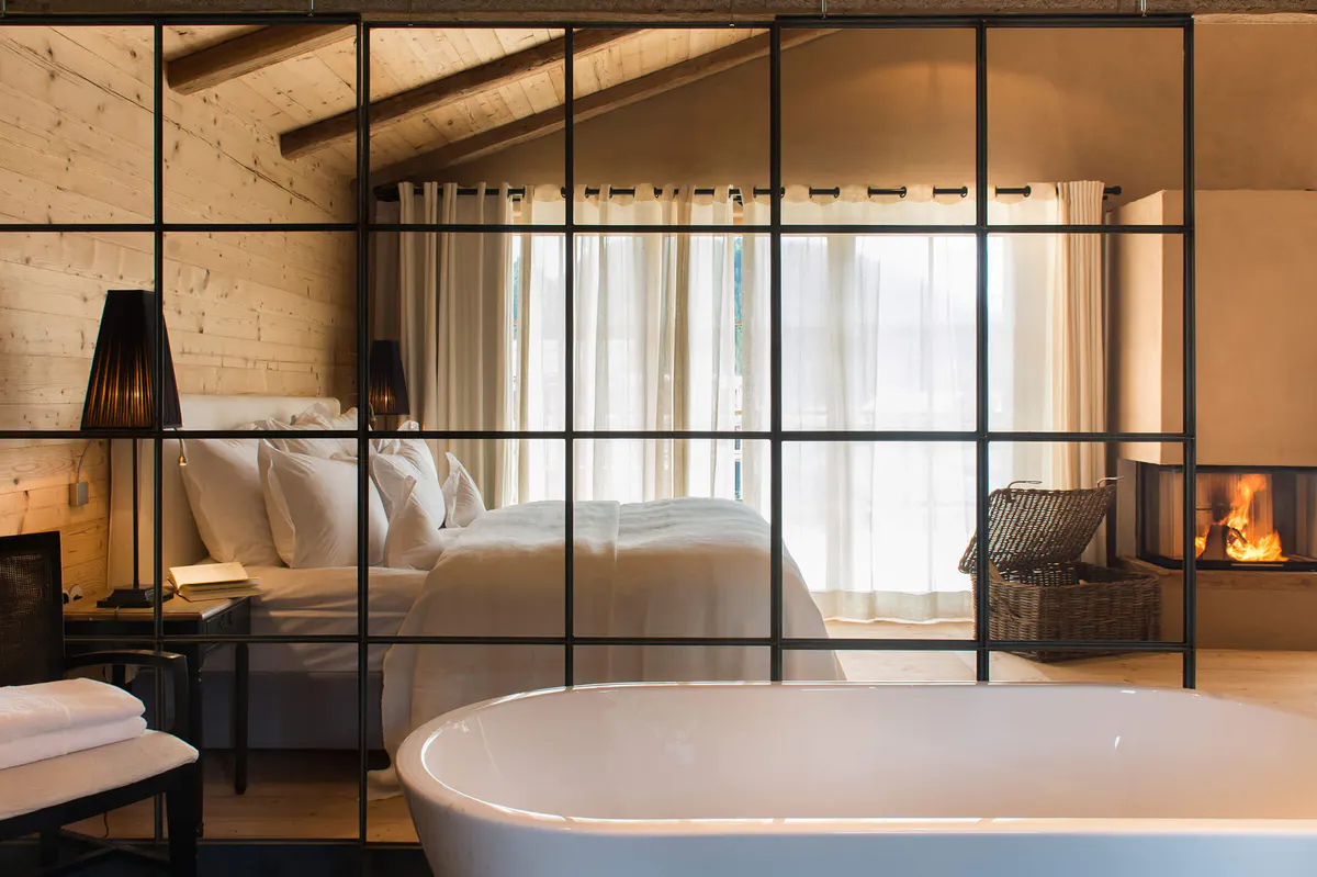 Modern freestanding white soaking tub with a frame partition and mountain view