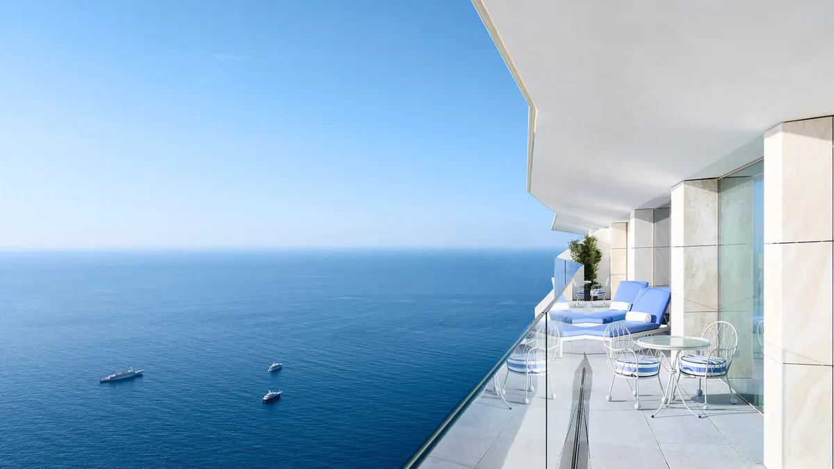 Infinity pool and terraced seating overlooking blue water