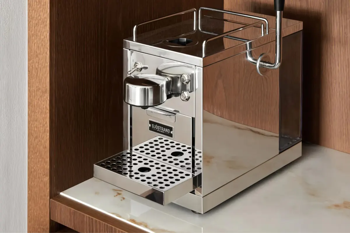 Espresso machine built into wood cabinetry in room amenities station