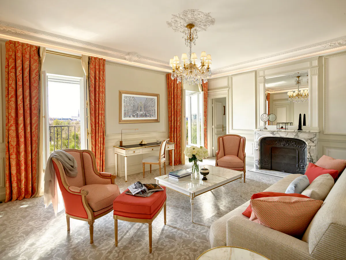 A suite living room in warm tones with terracotta upholstery and classical framed artwork