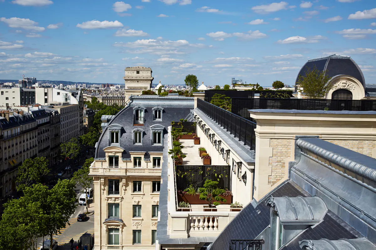 Aerial view of Parisian roofscape with historic buildings and clear sky