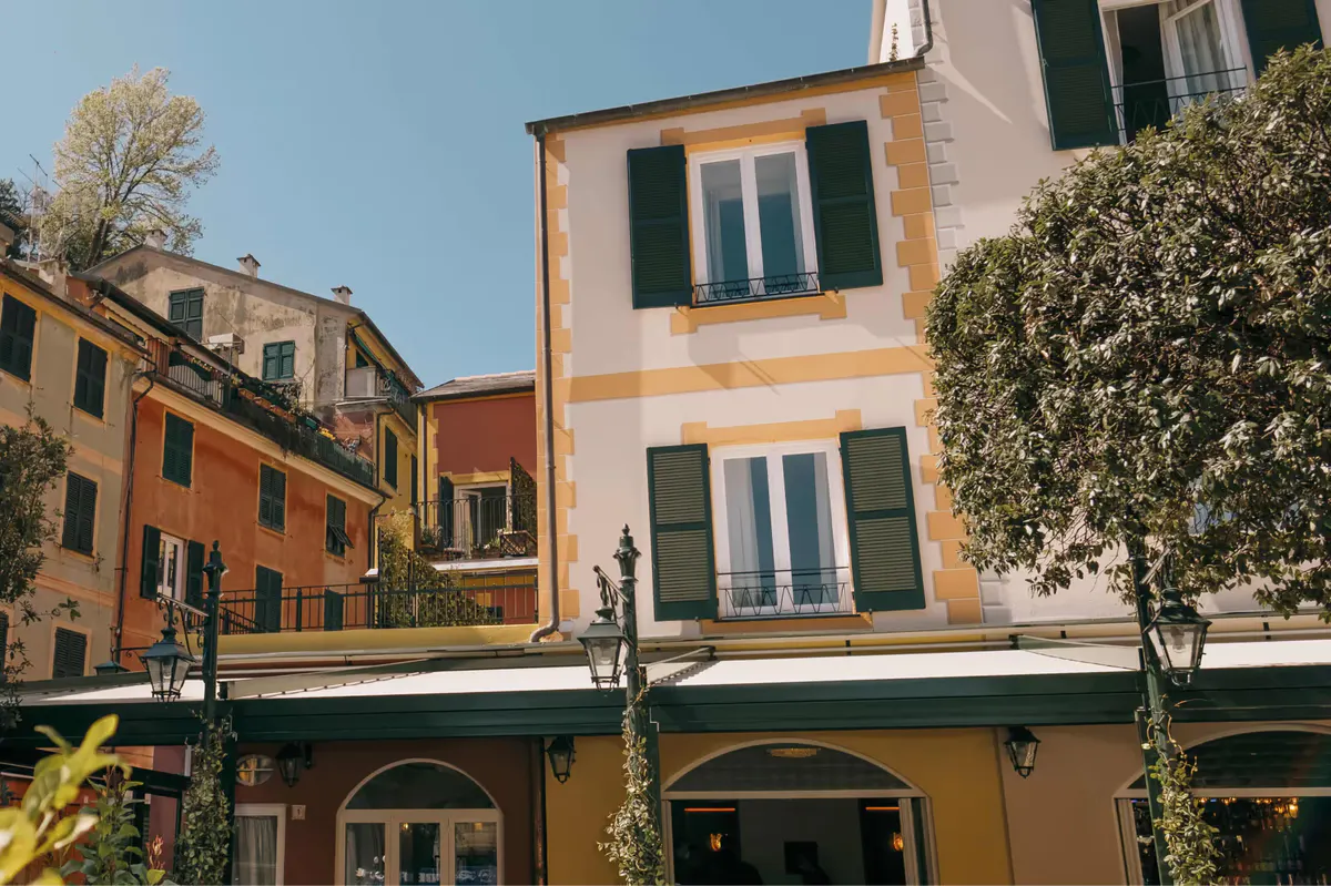 Hotel facade in orange and cream with green shutters