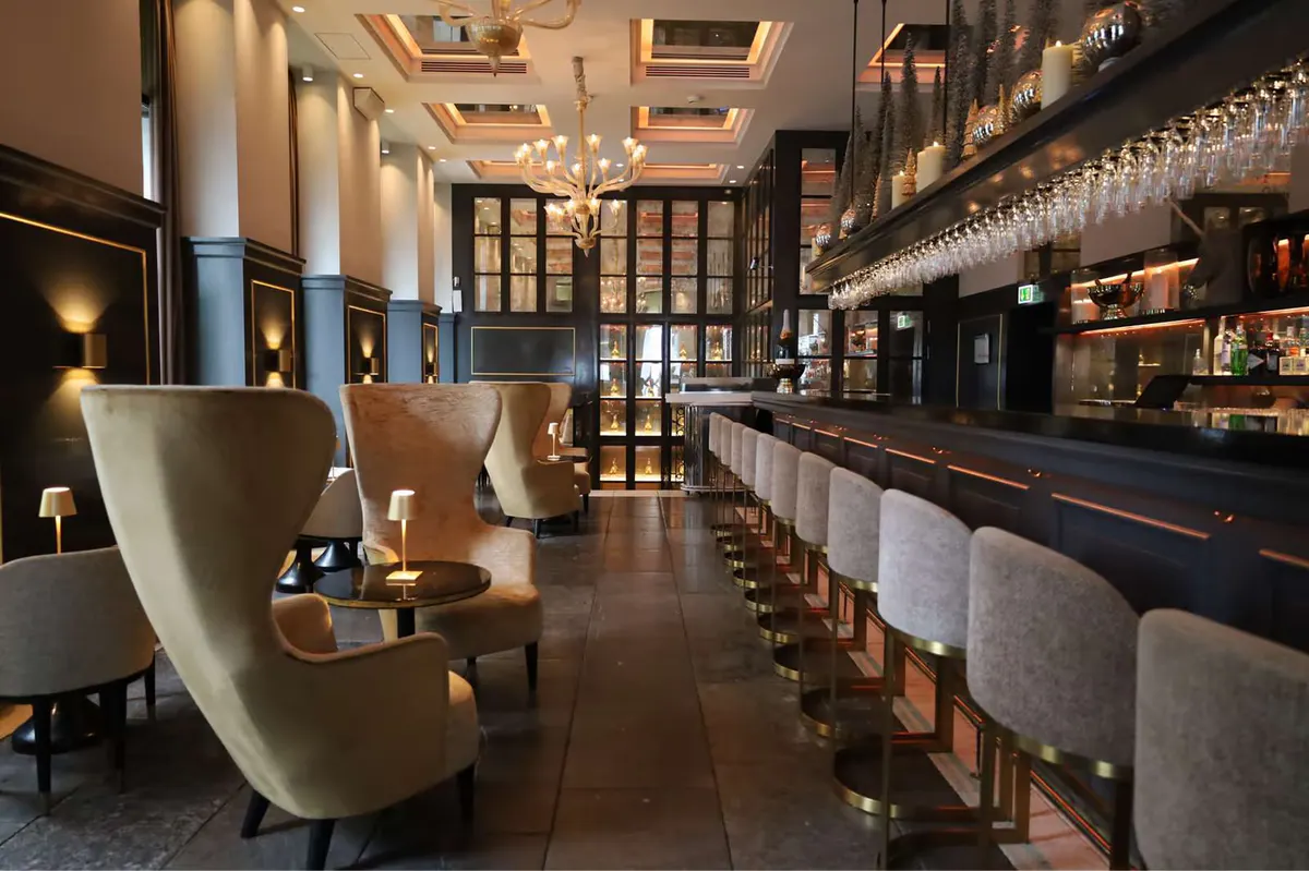 Bar counter with tall upholstered chairs and interior display shelving
