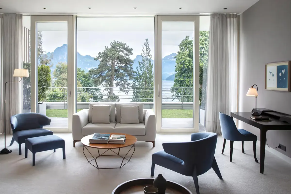 Modern living room with floor-to-ceiling windows, Alpine mountain views, and contemporary furnishings