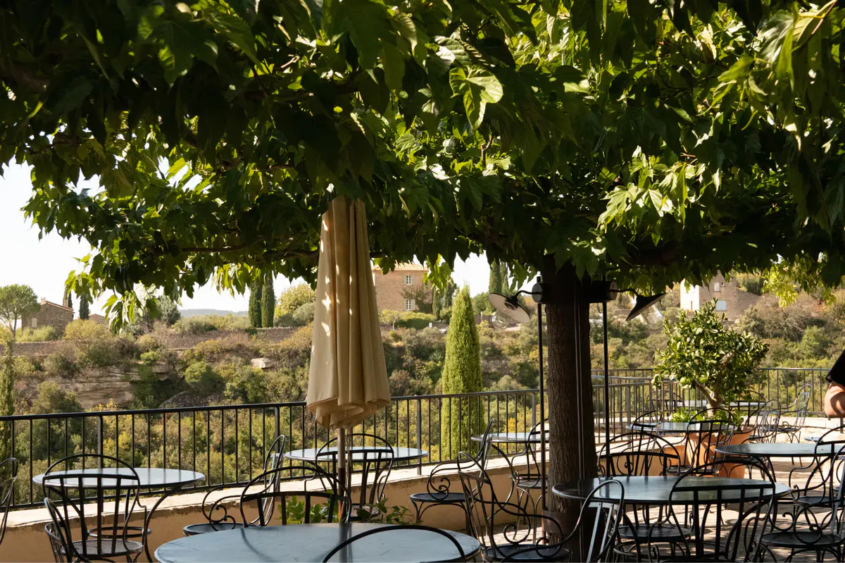 Terrace dining under grapevine canopy with valley and church views