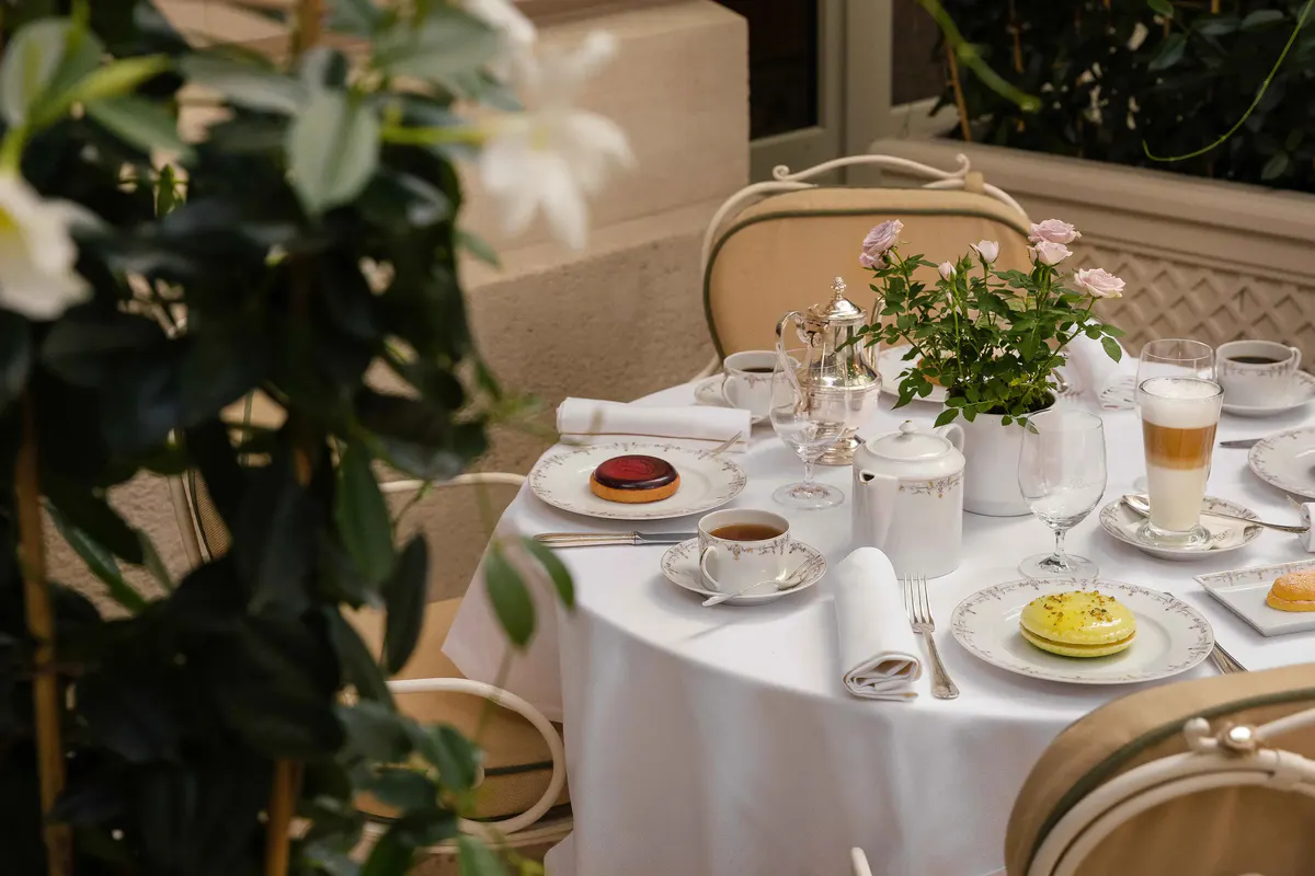 An intimate table setting with white linens, full place settings, and fresh floral arrangement
