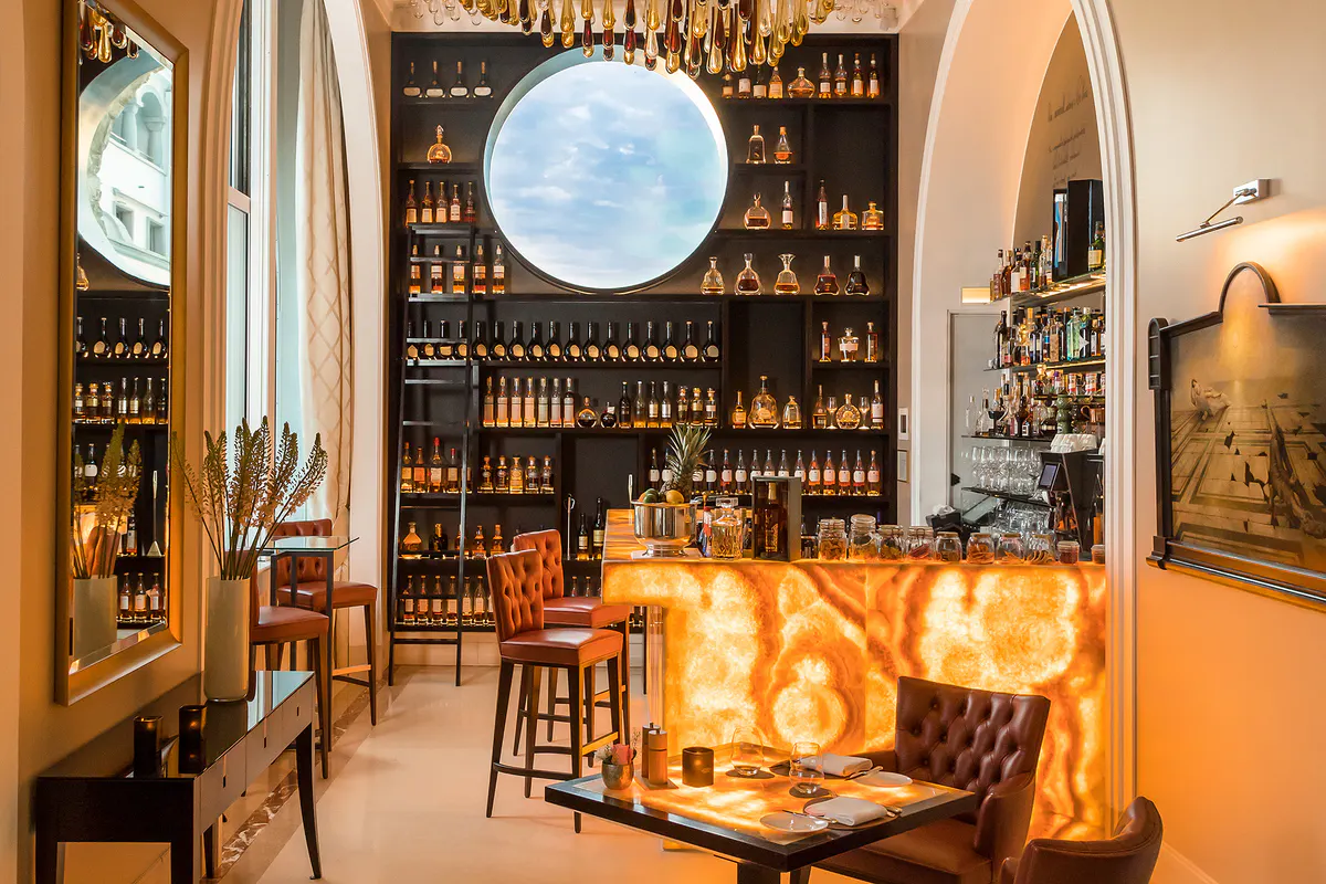 Wine bar with illuminated shelving and circular window overlooking the lake