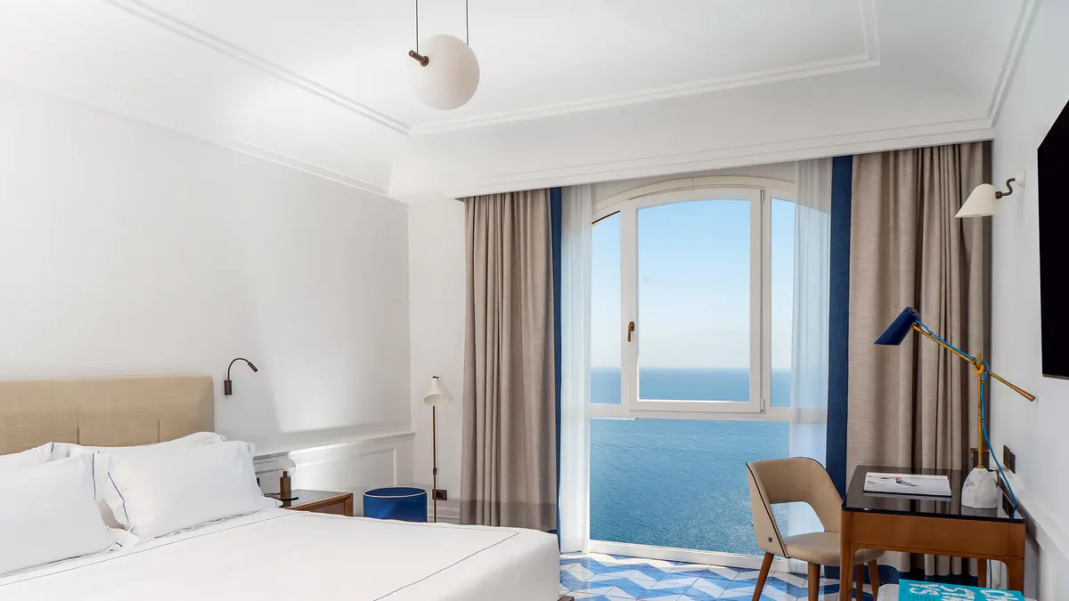 Bright bedroom suite with full-width ocean views and minimalist furnishings