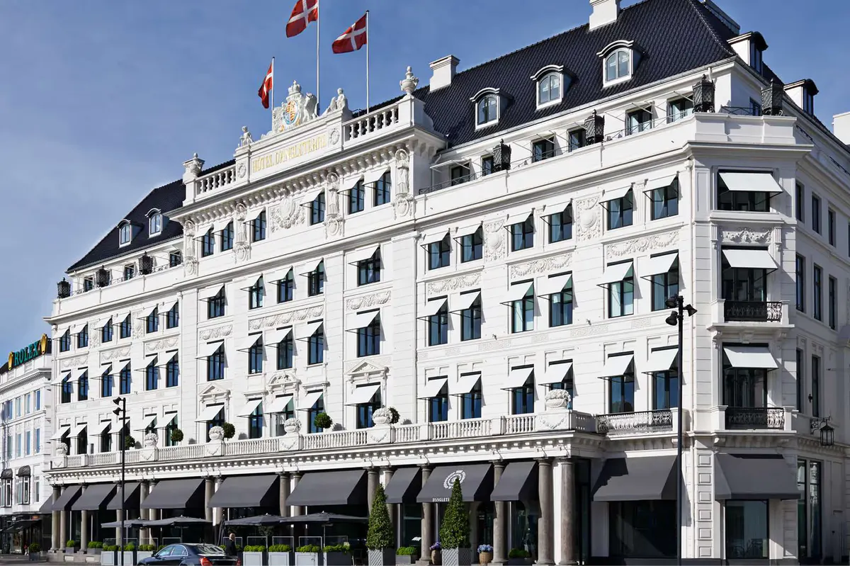 Historic pale stone facade on Kongens Nytorv square with slate roofline