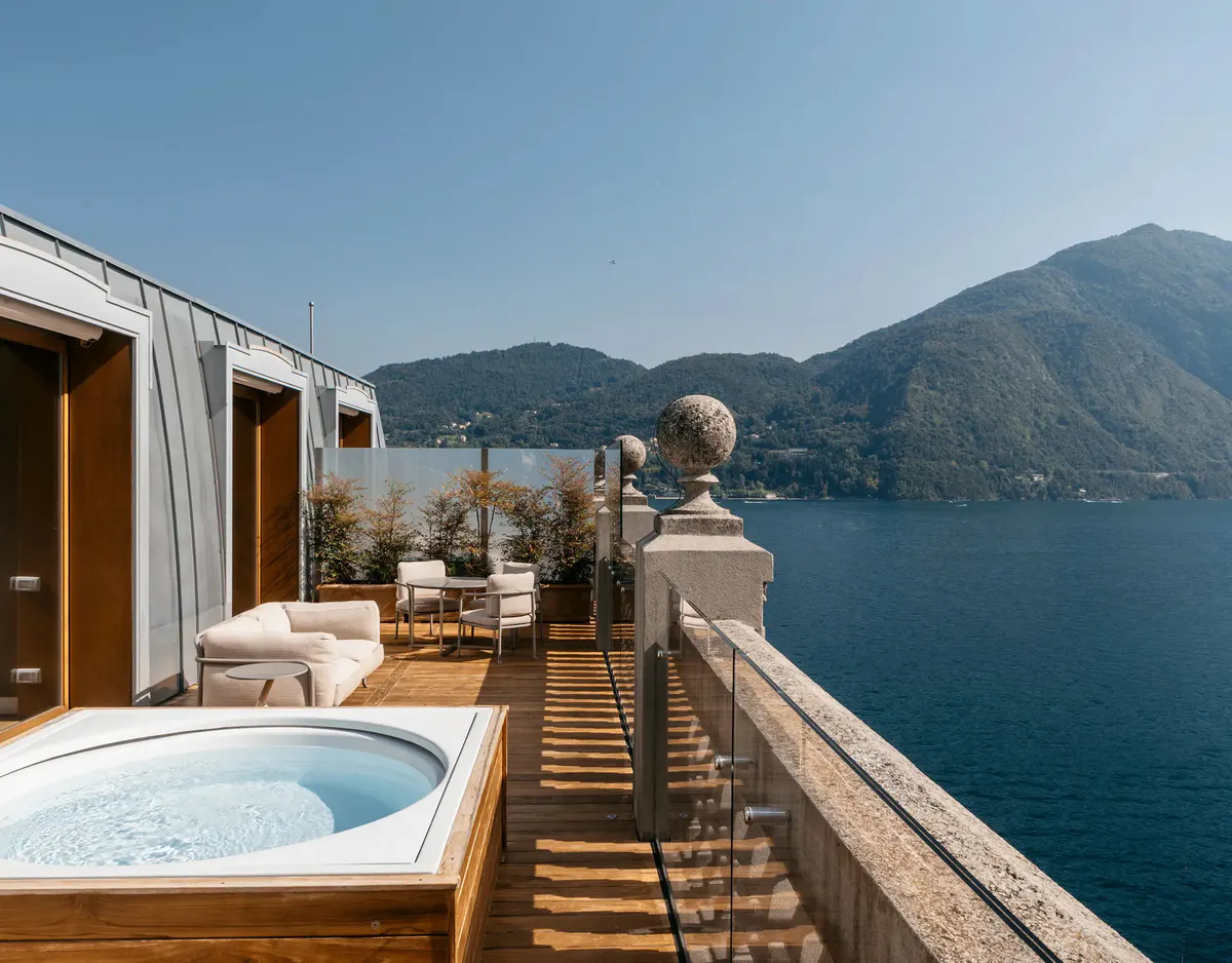 Waterfront suite terrace with hot tub and lake panorama at dusk