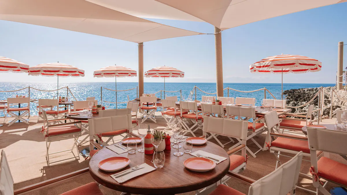 Beachfront dining with striped umbrellas and coastal setting