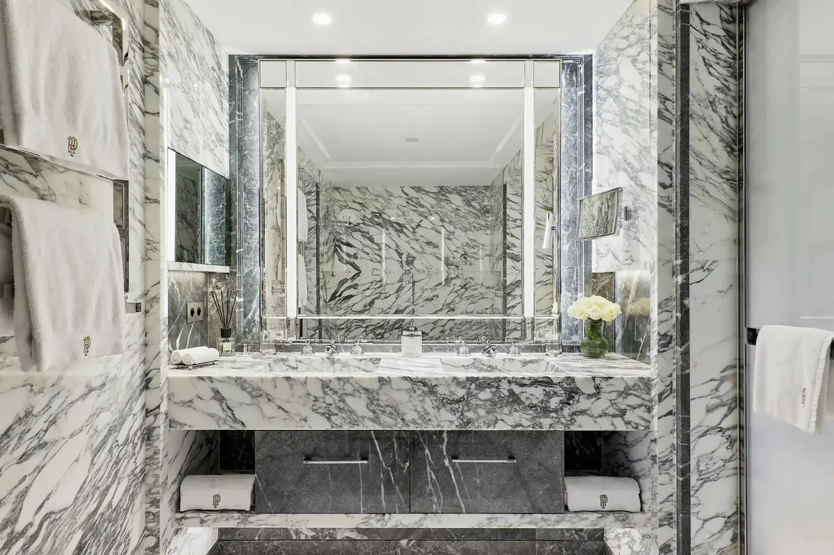 Marble bathroom with double vanity, large mirror and minimalist fixtures
