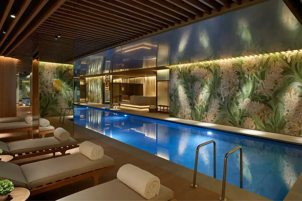 A modern spa pool with lounge seating and illuminated accent lighting in warm tones