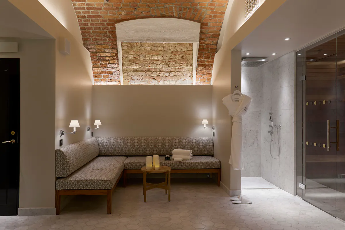 Spa relaxation lounge with exposed brick ceiling, bench seating, and ambient lighting