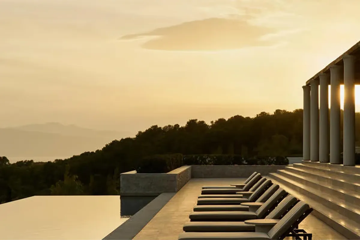 Waterside loungers at sunset with mountains and reflected sky